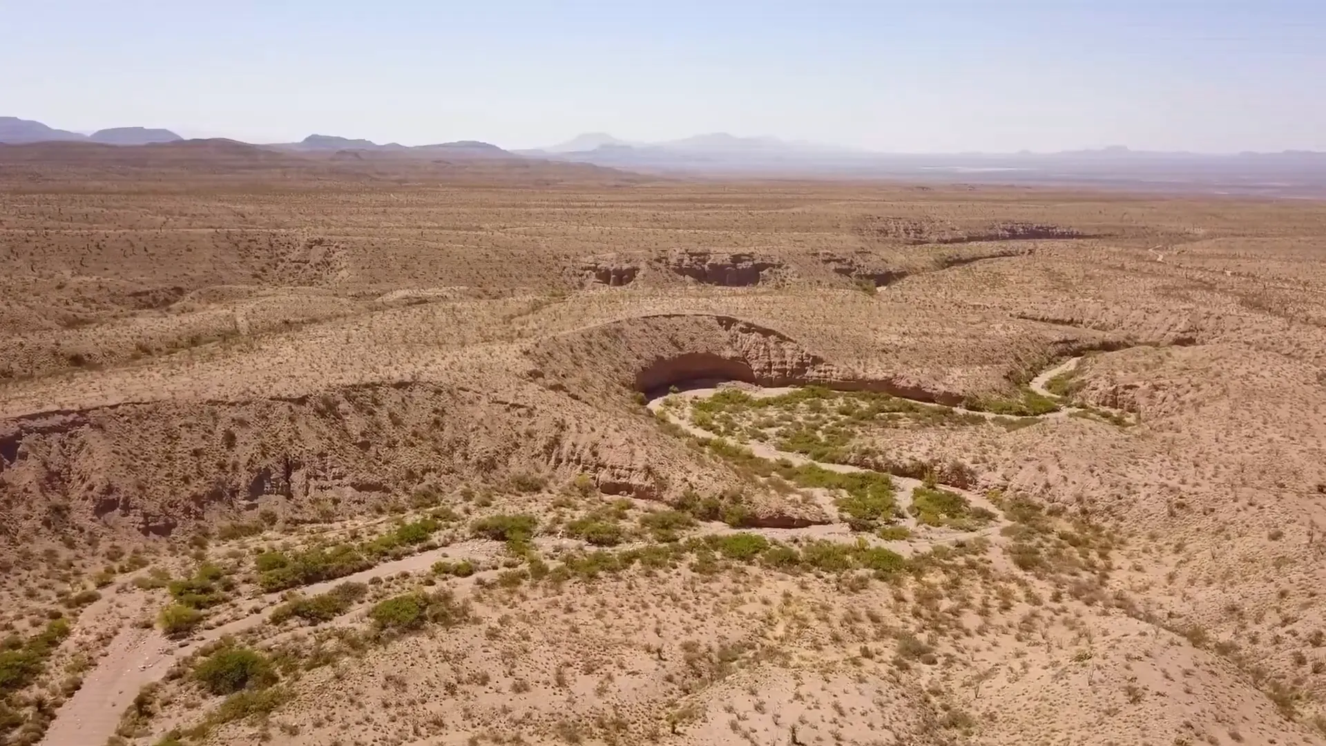 Still from a drone shot revealing vast desert land